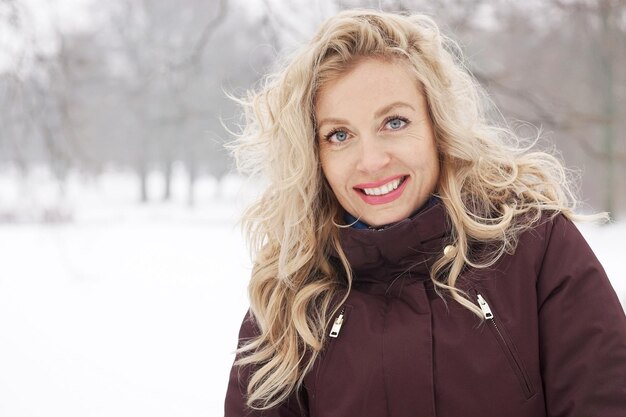 Foto portret van glimlachende vrouw in de sneeuw