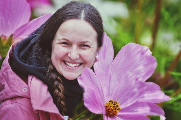 Portret van glimlachende vrouw met paarse bloem