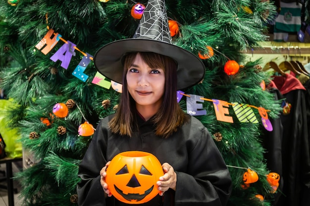 Foto portret van glimlachende vrouw met pompoen in het park tijdens halloween