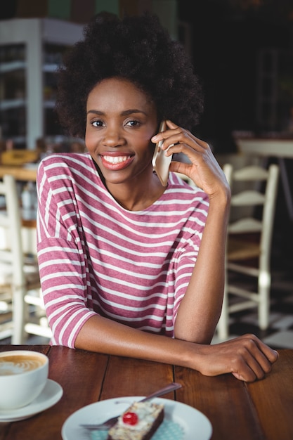 Portret van glimlachende vrouw praten op de mobiele telefoon