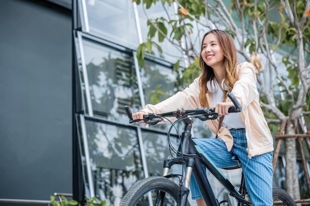 Foto portret van glimlachende vrouwelijke levensstijl met behulp van fiets in de zomer reis vervoermiddel