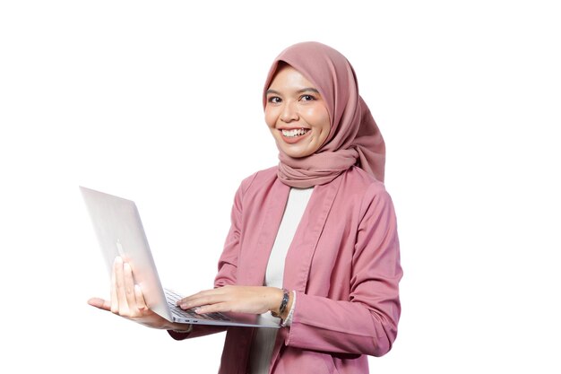 Portret van glimlachende zelfverzekerde Aziatische business designer vrouw roze pak kantoor met behulp van laptop