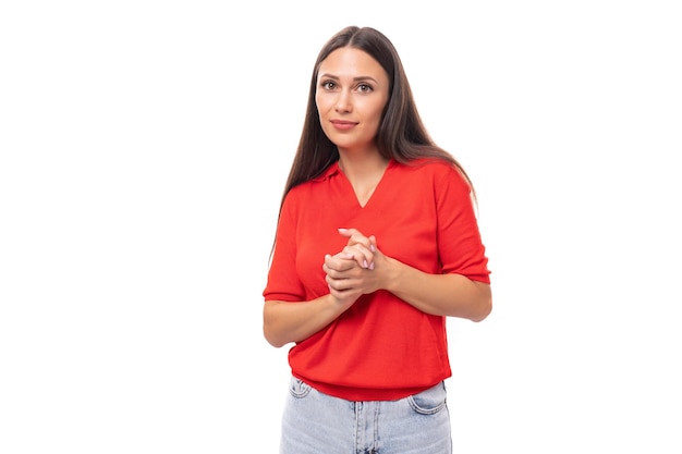 Portret van goed verzorgde donkerbruine vrouw met steil haar in rode t-shirt en jeans geïsoleerde studio