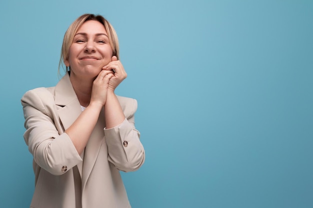 Portret van goed verzorgde Europese positieve blonde jonge vrouw in casual stijl op studio achtergrond