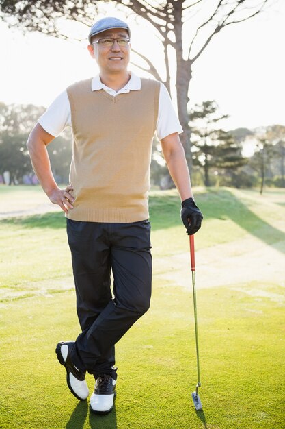 Portret van golfspeler het stellen met zijn golfclub