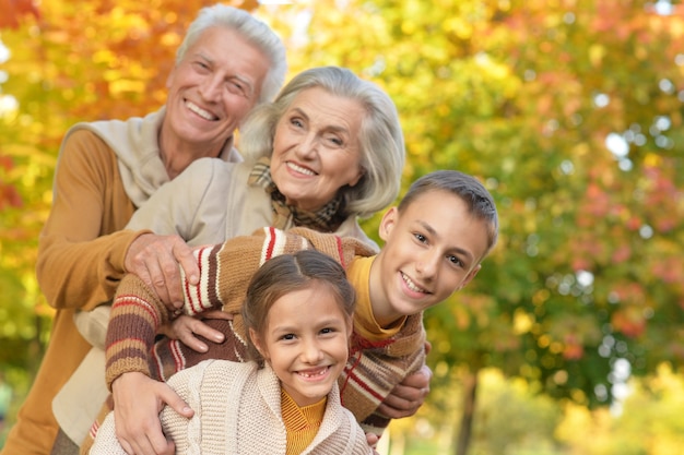 Portret van grootouders met kleinkinderen die in de herfst buiten poseren