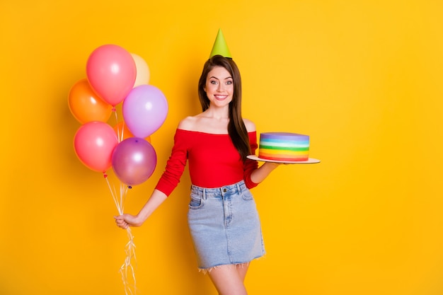 Portret van haar ze leuk aantrekkelijk mooi schattig vrolijk vrolijk funky meisje in de hand houden van zelfgemaakte taart helium ballen genieten van vrije tijd geïsoleerd helder levendig glans levendige gele kleur achtergrond