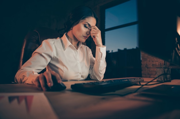 Portret van haar ze mooie aantrekkelijke uitgeput zakenlady agent makelaar topmanager advertentiebureau eigenaar hardwerkend lijden aan hoofdpijn 's nachts donkere werkplek station binnenshuis