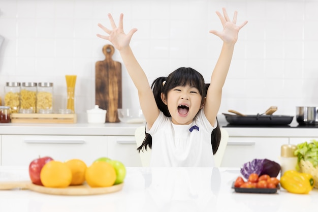 Foto portret van het aziatische meisje glimlachen in de keuken
