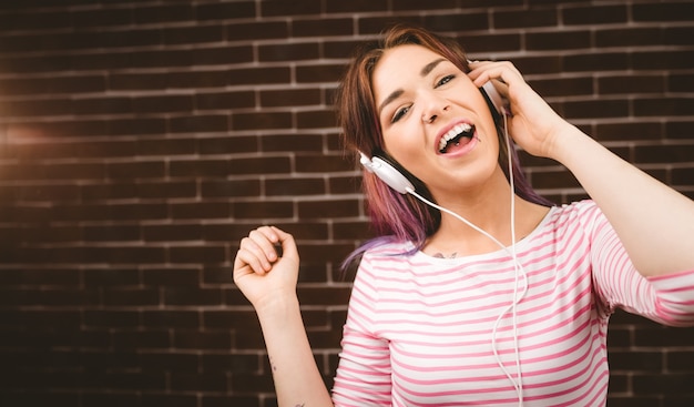 Portret van het glimlachen vrouw het luisteren muziek op hoofdtelefoons