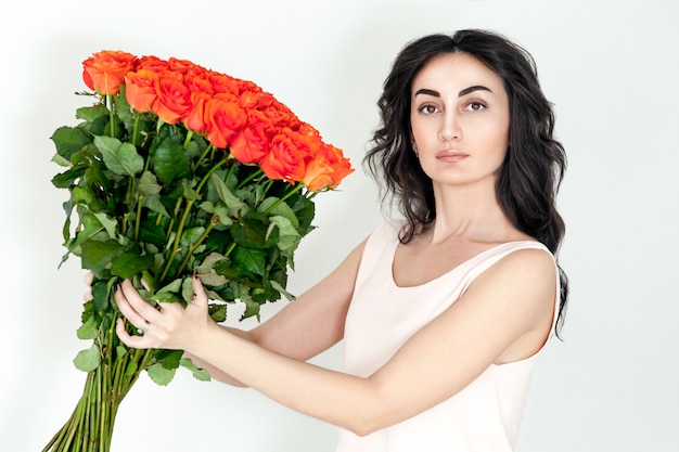 Portret van het lachende roodharige meisje met oranje rozen