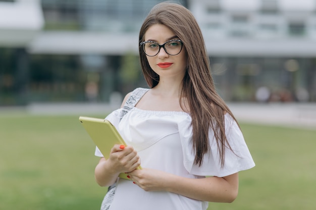 Portret van het meisje van de studententiener op de universiteit in openlucht