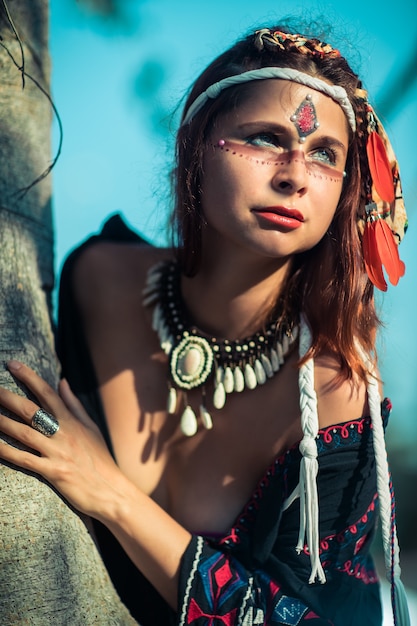 Portret van het mooie etnische vrouw openlucht stellen. creatieve make-up