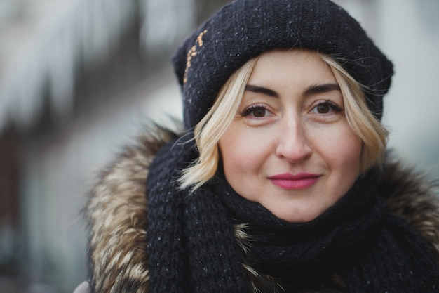 Portret van het mooie gelukkige glimlachende vrouw stellen buiten in de winter.