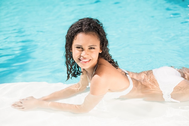 Portret van het mooie vrouw ontspannen door poolside