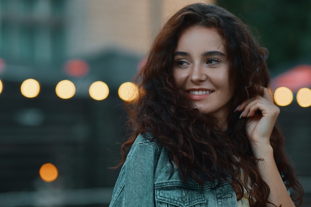 Portret van het mooie vrouw stellen over vage lichten