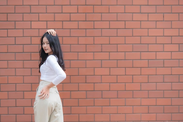 Portret van hipster meisje op bakstenen muur achtergrond Mooie Aziatische vrouw poseren voor het nemen van een foto Kawaii stijl