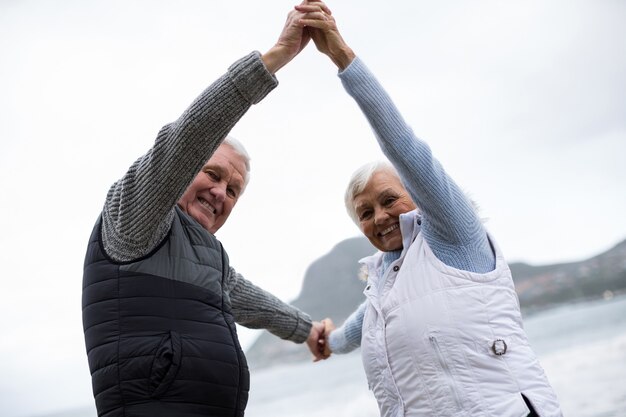 Portret van hoger paar die pret hebben samen bij strand