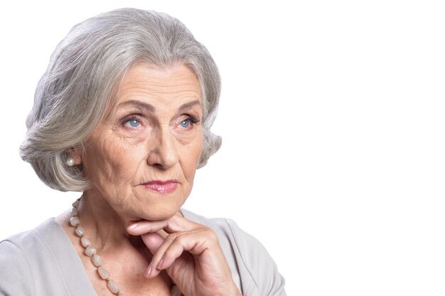 Portret van hogere vrouw die op witte achtergrond wordt geïsoleerd