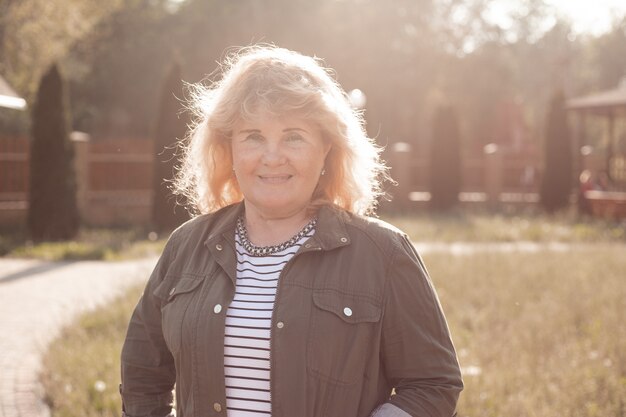 Portret van hogere vrouw in de zomer parkon zonsondergang