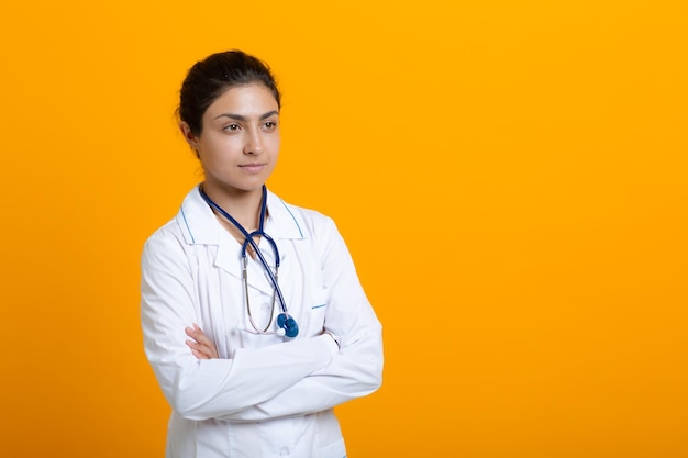 Portret van Indiase arts vrouw in witte medische jurk geïsoleerd op gele achtergrond