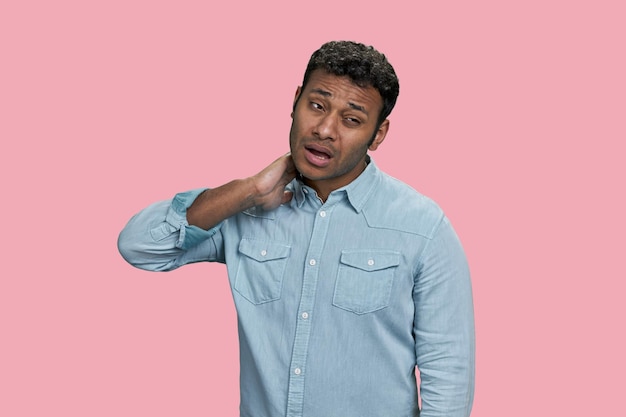 Portret van Indiase man die lijdt aan nekpijn geïsoleerd op roze achtergrond