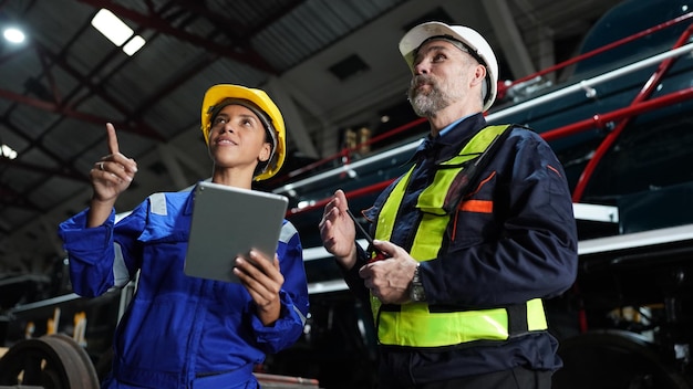 Foto portret van ingenieur en leerling in werkplaats van spoorwegtechnische faciliteit fabriek