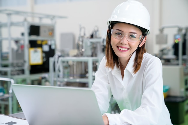 portret van ingenieur lach met laptop over progressie van productielijn volgen werken