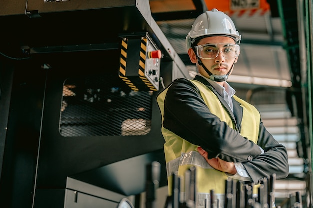 Portret van inspecteursmanager met veiligheidshelm en het dragen van een brilmachines in fabriekswerkplaats Ingenieur