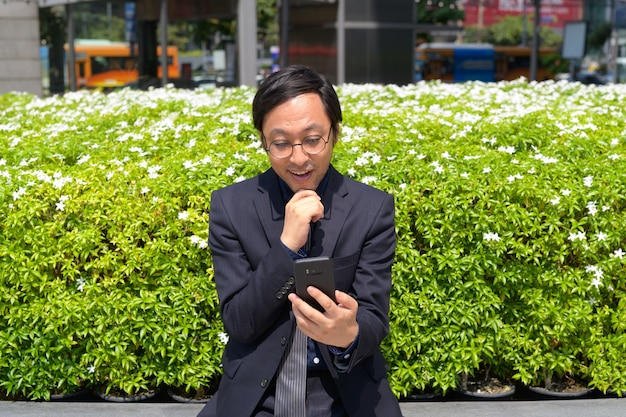 Portret van Japanse zakenman die frisse lucht met de natuur in de stad buitenshuis krijgt