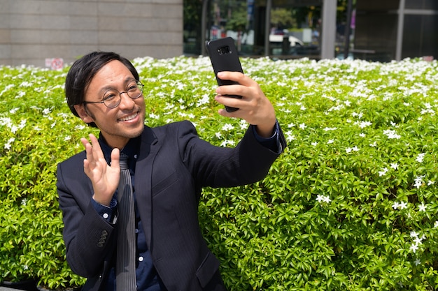 Portret van Japanse zakenman die frisse lucht met de natuur in de stad krijgt