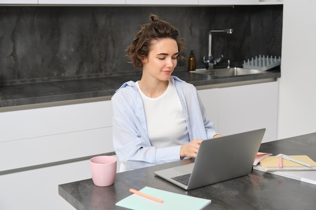 Portret van jaren vrouw studeert online kijkt cursus in internet werkt op laptop vanuit haar huis