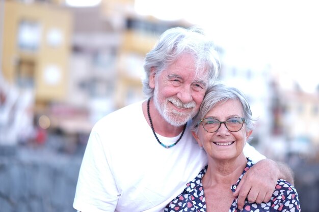 Portret van jeugdige senior paar omarmen in buiten bij zonsondergang licht. blanke witharige mensen genieten van ontspanning en vrijheid