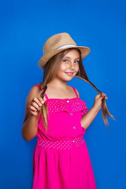 Portret van jong leuk meisje in roze kleding en hoed De zomervakantie en reisconcept