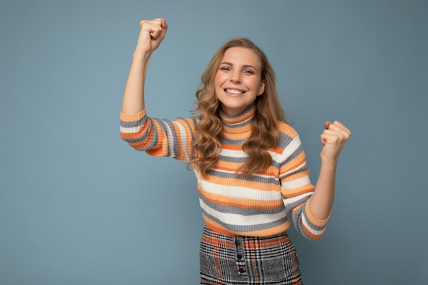 Portret van jonge aantrekkelijke aantrekkelijke gelukkig lachende blonde vrouw met golvend haar gestreept dragen