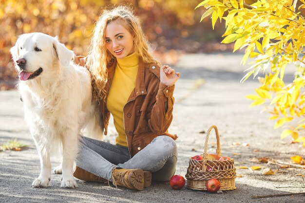 Portret van jonge aantrekkelijke blond meisje met hond. Huisdier eigenaar. Golden retriever en zijn eigenaar in de herfst.