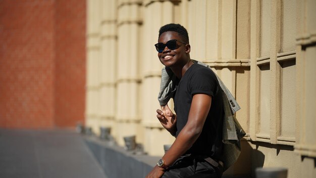 Portret van jonge aantrekkelijke stijlvolle Afro-Amerikaanse man model poseren in casual kleding tegen neutrale achtergrond op zoek sexy met afro haar. In mensen jeugd schoonheid en mode concept.