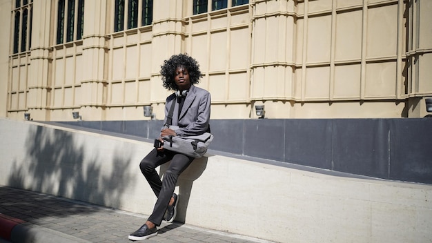 Portret van jonge aantrekkelijke stijlvolle Afro-Amerikaanse man model poseren in casual kleding tegen neutrale achtergrond op zoek sexy met afro haar. In mensen jeugd schoonheid en mode concept.