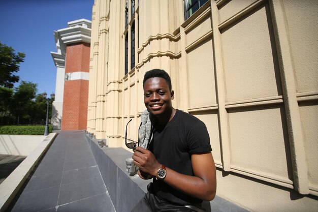 Portret van jonge aantrekkelijke stijlvolle Afro-Amerikaanse man model poseren in casual kleding tegen neutrale achtergrond op zoek sexy met afro haar. In mensen jeugd schoonheid en mode concept.