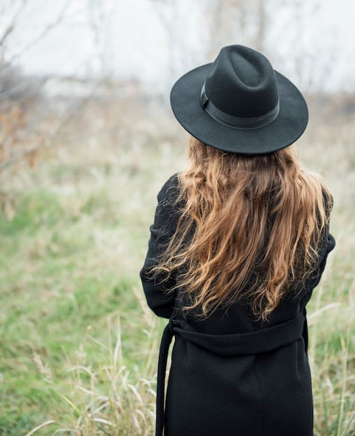 Portret van jonge aantrekkelijke vrouw in zwarte jas en hoed