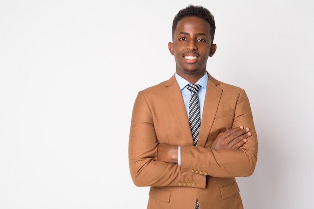 Portret van jonge Afrikaanse zakenman met Afrohaar in bruin kostuum tegen witte muur