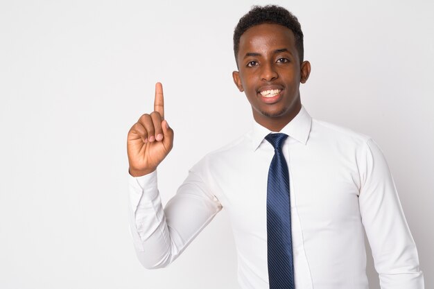 Portret van jonge Afrikaanse zakenman met Afrohaar tegen witte muur