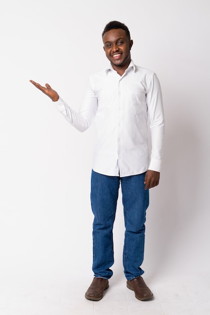 Portret van jonge Afrikaanse zakenman tegen witte muur