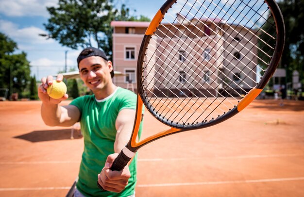 Portret van jonge atletische man op tennisbaan