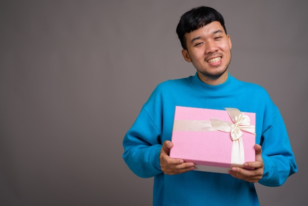 Portret van jonge Aziatische man met geschenkdoos