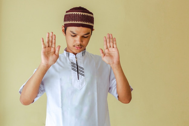 Portret van jonge Aziatische moslimman salat met het opheffen van zijn hand of takbiratul ihram