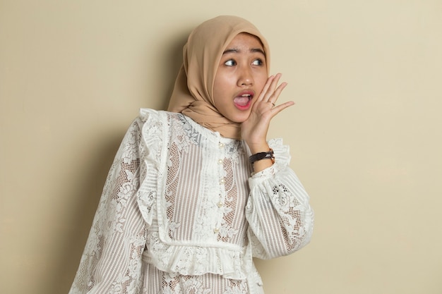 Portret van jonge Aziatische moslimvrouw die hijab draagt die en schreeuwt schreeuwt