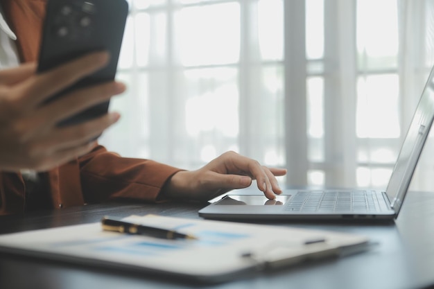 Portret van jonge Aziatische vrouw hand freelancer werkt haar baan op computertablet in modern kantoor Doen boekhoudkundige analyse rapport onroerend goed investeringsgegevens Financieel en fiscale systemen concept