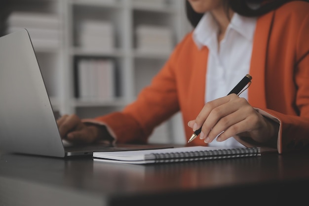 Portret van jonge Aziatische vrouw hand freelancer werkt haar baan op computertablet in modern kantoor Doen boekhoudkundige analyse rapport onroerend goed investeringsgegevens Financieel en fiscale systemen concept