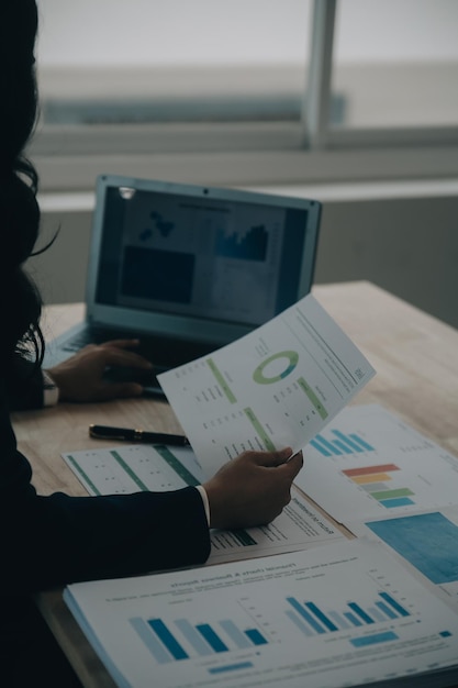 Portret van jonge Aziatische vrouw hand freelancer werkt haar werk op een computer tablet in een modern kantoor Het doen van boekhoudkundige analyse rapport vastgoed investeringen gegevens financieel en fiscaal systeem concept